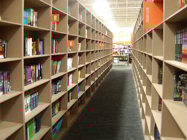 Store displaying tall and long bookcases filled with books