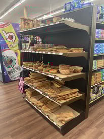 Retail end cap display unit placed at aisle end, used for showcasing promotional or high-visibility products in a store environment.