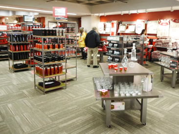 Store displaying modular fixtures, tables, and shelving racks with school branded merchandise