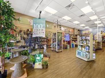 Store showing wire grid displays with wind chimes, bird seed, and feeders