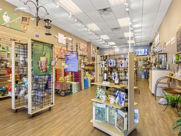 Store showing wire grid displays with wind chimes, bird seed, and feeders