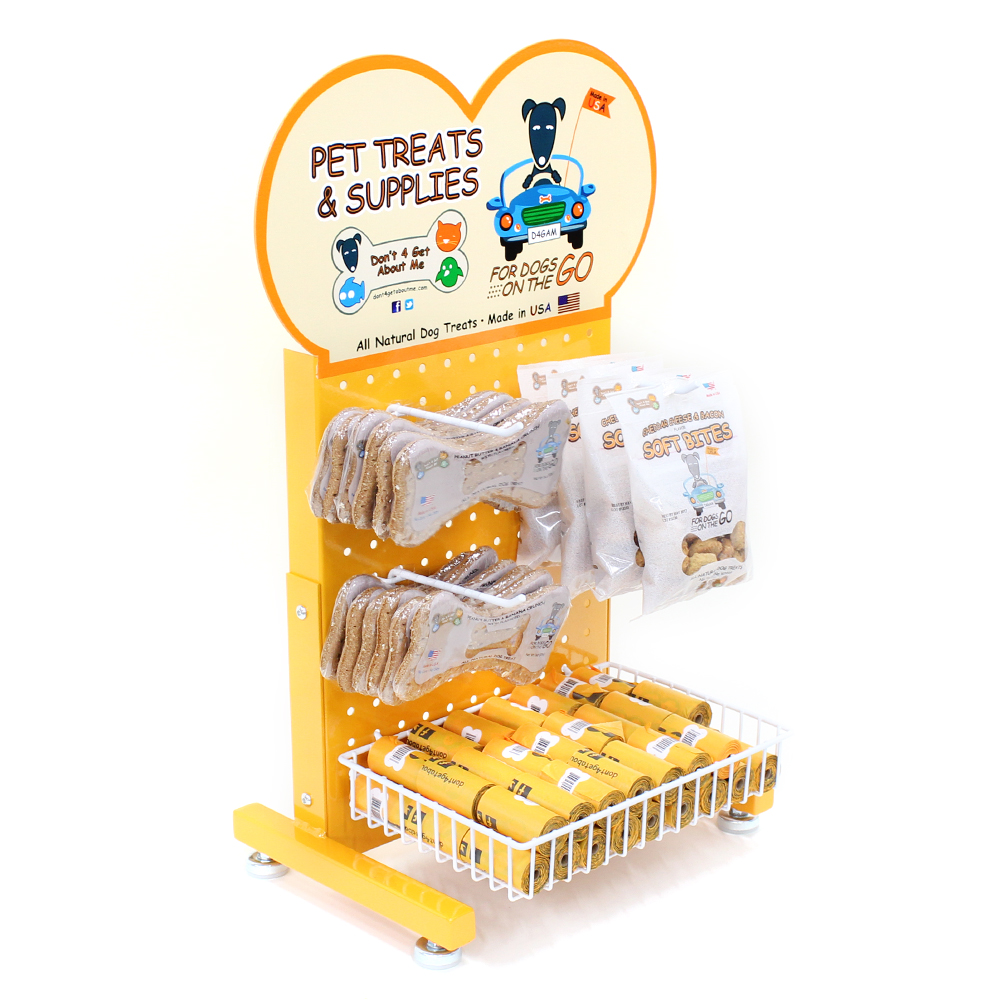 Yellow pet treat display stand with dog graphics, holding bone-shaped treats and "Soft Bites" bags. Made in USA.